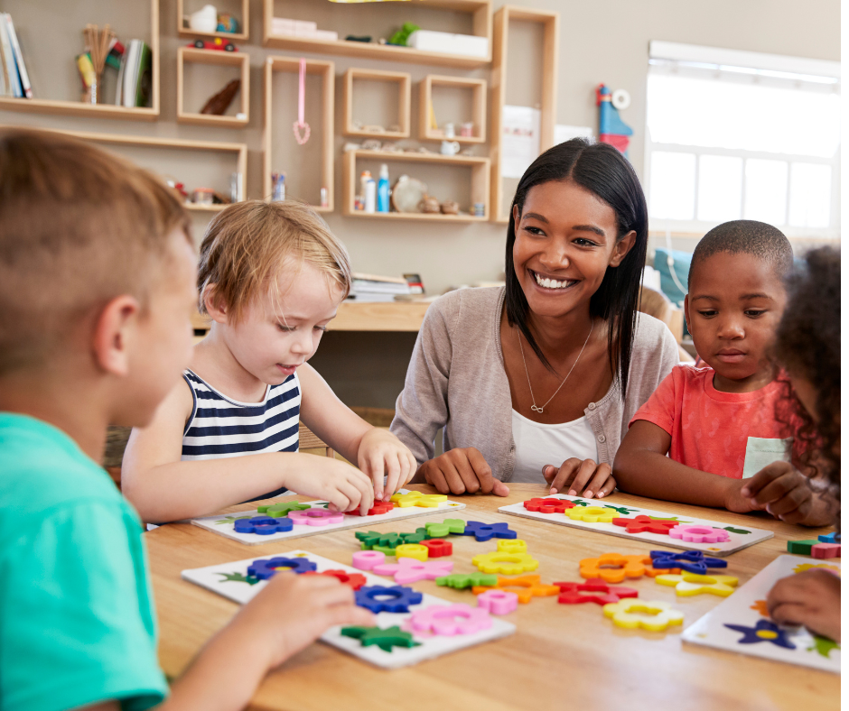 Teacher At Table With Young Kids